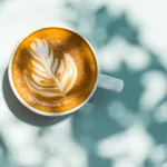 یک فنجان قهوه با طرح فوم تزئینی روی سطح